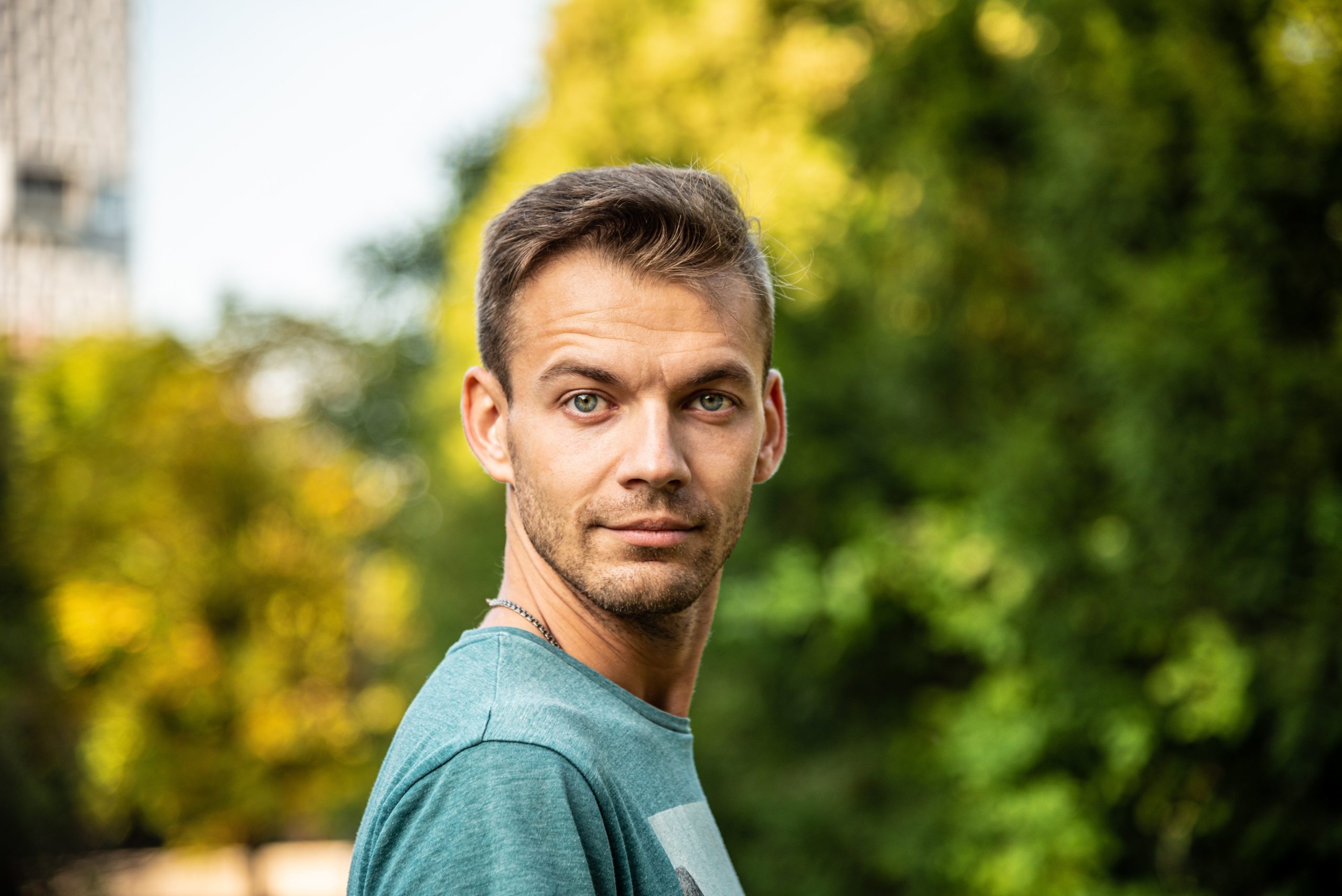 Man in his late 30s looking over his shoulder